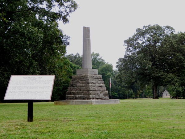 This monument marks the burial site of Meriwether Lewis. The ruins of the Grinder house are visible on the ground adjacent to the visitor's center, far right. Natchez Trace Parkway, Lewis County, Tennessee, September 18, 2014